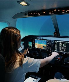 two people are sitting in the cockpit of an airplane and one person is looking at the screen