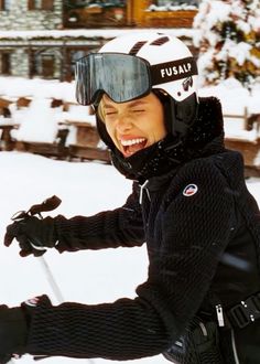 a woman riding skis on top of snow covered ground