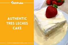 a piece of cake with white frosting and strawberries on the top, sitting on a plate