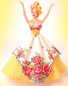 a barbie doll wearing a yellow and white dress with flowers on it's skirt