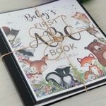 the baby's first book is decorated with woodland animals and letters that spell out their name