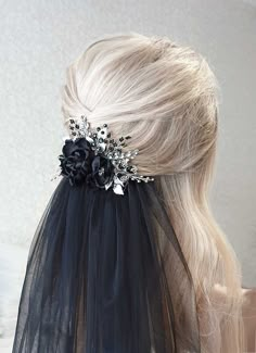 the back of a woman's head wearing a black veil with flowers on it