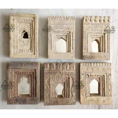 four carved wooden frames with carvings on the sides and an opening in the middle to reveal a window