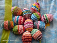 colorful knitted easter eggs on a blue and green blanket