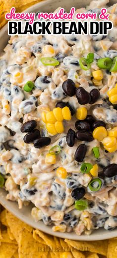 a bowl filled with black bean dip surrounded by corn and tortilla chips