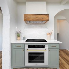 a stove top oven sitting inside of a kitchen next to a wall mounted range hood