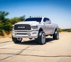 a white ram truck driving down the road