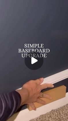 a person is holding a piece of cardboard with the words simple baseboard upgrade on it