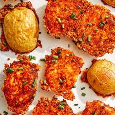 some fried food is laying out on a white surface with green onions and breadcrumbs