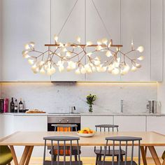 a dining room table with chairs and a chandelier hanging from it's ceiling