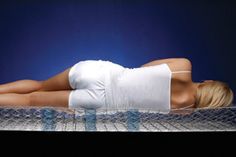 a woman laying on top of a metal bed