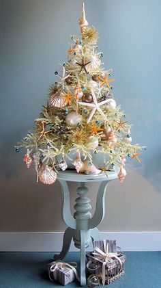 a white christmas tree with starfish and seashells on it in a room