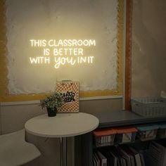 this classroom is better with you in it neon sign next to a table and chairs