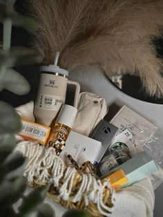 an assortment of items sitting on top of a table next to a plant and mirror