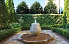 an outdoor fountain in the middle of a garden