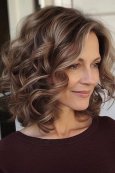 Add a hint of romance to your style with a medium haircut with soft curls. This style is perfect for individuals who have curly or wavy hair; it increases the volume and also makes it more textured. Click here to check out more best medium-length hairstyles for women over 50. Medium Length Haircut With Layers For Curly Hair, Medium Length Hair For Curly Hair, Medium Wavy Hair Styles For Women, How To Soft Curls For Medium Hair, Hairstyles For Medium Length Hair Curly Soft Curls, Curl Hair Medium Length, Medium Length Hair With Curls Style, Shoulder Length Hair Styles Curly, Hairstyles For Shoulder Length Wavy Hair