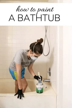 a woman in grey shirt and black gloves cleaning bathtub