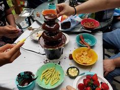 people sitting around a table with plates and bowls of food on it, including strawberries