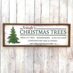 a christmas tree sign hanging on the side of a wooden wall next to a door