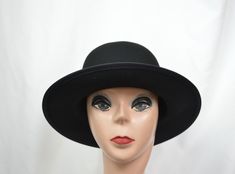 This black wool felt hat has a flat 2 1/2-inch brim and rounded crown. The small/medium will fit 21 to 22 1/2-inch head size, (there is a sizing cord inside the band to adjust to your head size), the large will fit up to 23 1/4 inch head size and the XLG will fit up to 24 1/8 inch head size. This hat is made in a classic vintage Annie Hall style hat and is suitable for any fall and winter weather. Brimmed Felt Hat, Classic Black Cloche Hat With Wide Brim, Classic Black Wide Brim Cloche Hat, Black Wool Felt Hat With Flat Brim, Classic Black Wool Cloche Hat, Classic Solid Color Cloche Felt Hat, Wide Brim Wool Mini Hats, Black Fur Felt Hat With Curved Brim, Black Wool Cloche Hat With Flat Brim