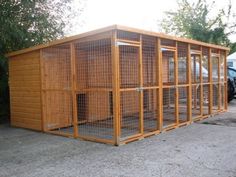 a large wooden structure with several cages in it's sides and one on the other side