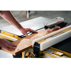 a person using a table saw to cut wood