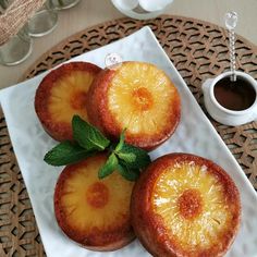 three pieces of pineapple sitting on top of a white plate next to a cup