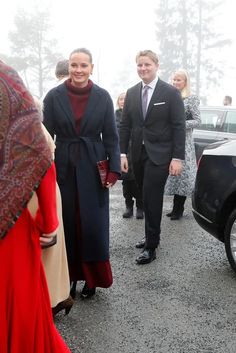 two men and a woman are walking in the rain