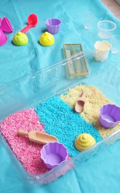 a plastic container filled with cake batter and cupcakes on top of a blue table cloth