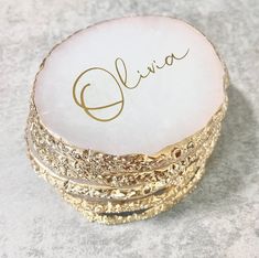 a stack of gold rings with the name eliine written on it in cursive writing