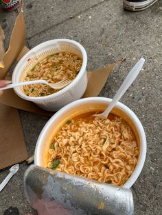 two bowls of ramen are sitting on the ground