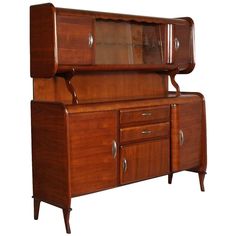 an old fashioned wooden cabinet with glass doors