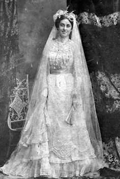 an old black and white photo of a woman in a wedding dress with a veil