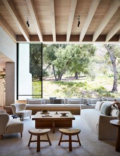 a living room filled with furniture and large windows