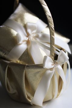 a gold basket with white ribbons on it