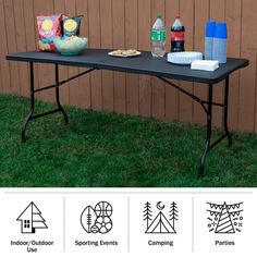 a table with food and drinks on it in front of a wooden fence, surrounded by grass