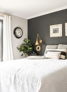 a bedroom with a large bed and clock on the wall