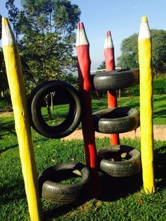 there are many pencils and tires in the grass near some poles that have been made out of them