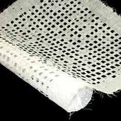 a piece of white fabric with black dots on the top and bottom, sitting on a black surface