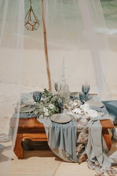 a table set up on the beach for an outdoor dinner