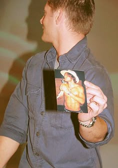 a man holding up a card with an image on it