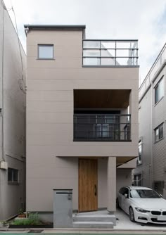 a car parked in front of a building with a balcony on the top floor and balconies above it