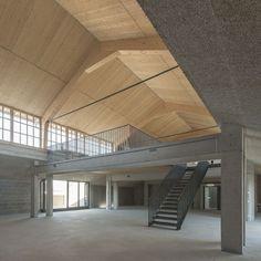 an empty building with stairs and windows in the ceiling, next to a staircase that leads up to another floor