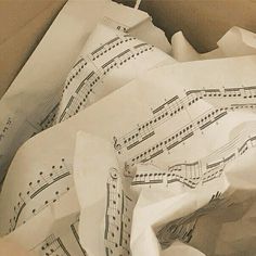 an open box with sheet music on it and paper in the bottom right hand corner