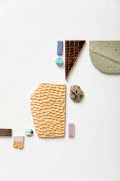 various objects are arranged on a white surface, including an umbrella and other items that appear to be made out of clay