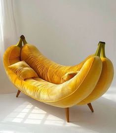 a banana shaped chair sitting on top of a white floor in front of a window