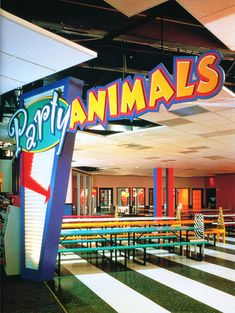 the entrance to an indoor party with tables and benches in front of it that says party animals