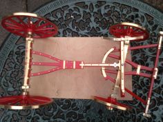 an aerial view of a metal structure with red wheels and spokes on the ground