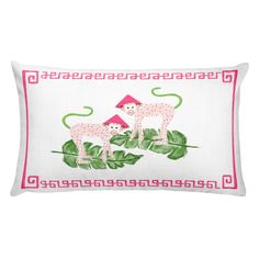 a white pillow with pink trim and two monkeys on top of green leafy branches