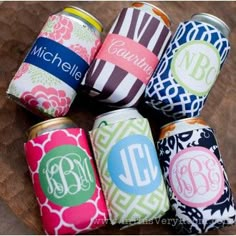 six personalized can coolers sitting on top of a wooden table with monogrammed labels